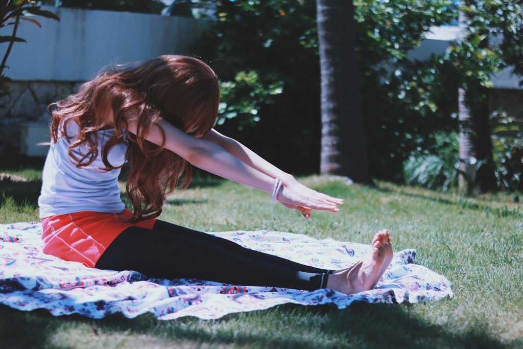 芝生の上で前屈している女性の画像