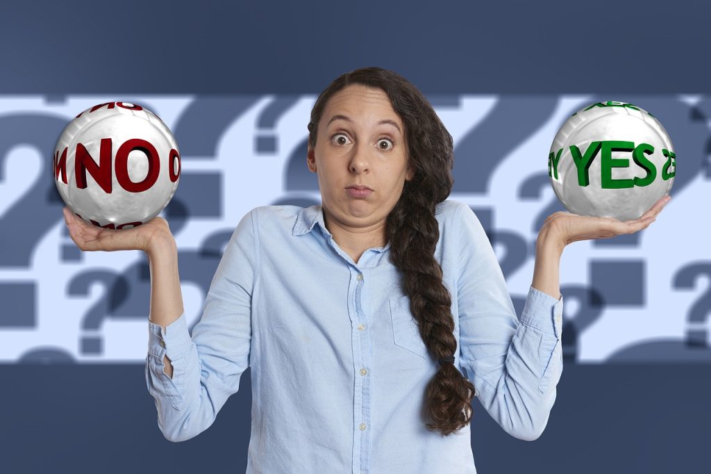 女性がYES・NOと書かれたボールをそれぞれ両手に持っている画像